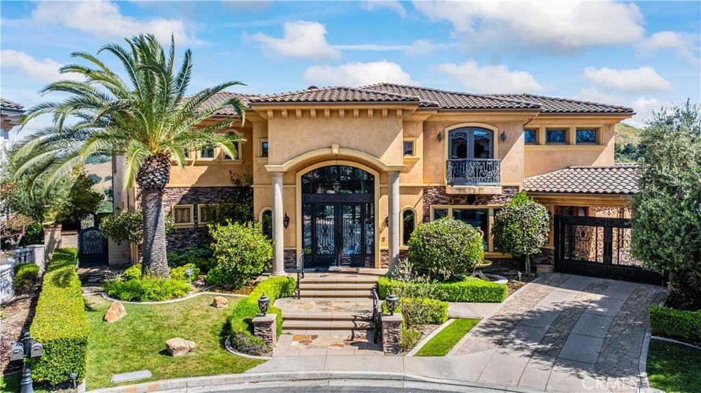 mediterranean / spanish-style home with french doors and a balcony