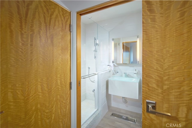 bathroom featuring sink, vaulted ceiling, and an enclosed shower