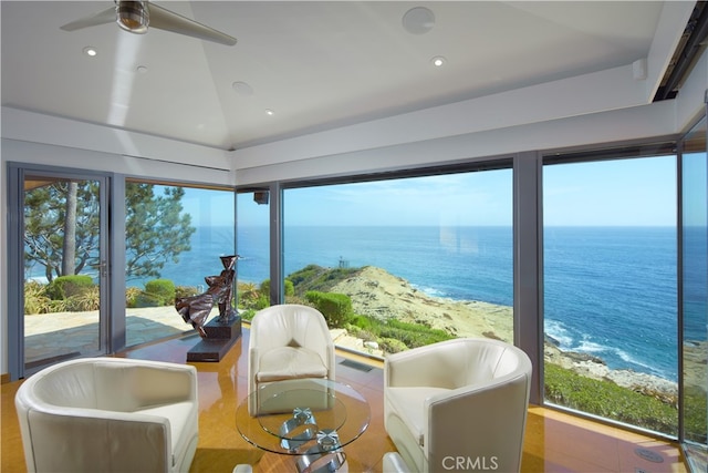 sunroom / solarium featuring ceiling fan, a beach view, vaulted ceiling, and a water view