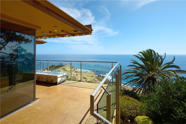 balcony featuring a water view and a beach view