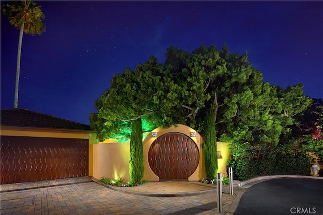 gate at twilight with a garage