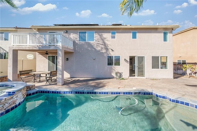 back of house featuring a patio, a balcony, ceiling fan, and a pool with hot tub