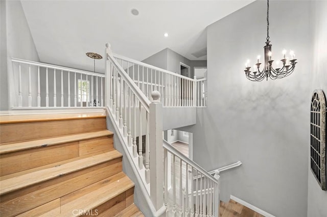 stairway featuring wood-type flooring and a notable chandelier