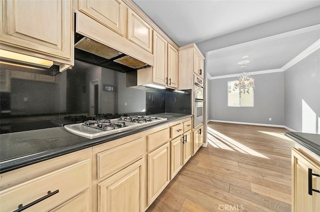 kitchen featuring light wood-type flooring, stainless steel gas cooktop, crown molding, light brown cabinets, and a notable chandelier