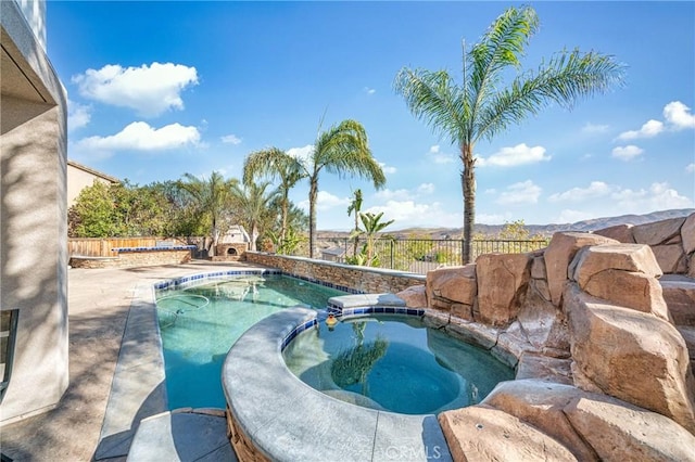 view of pool featuring an in ground hot tub, an outdoor stone fireplace, and a patio area