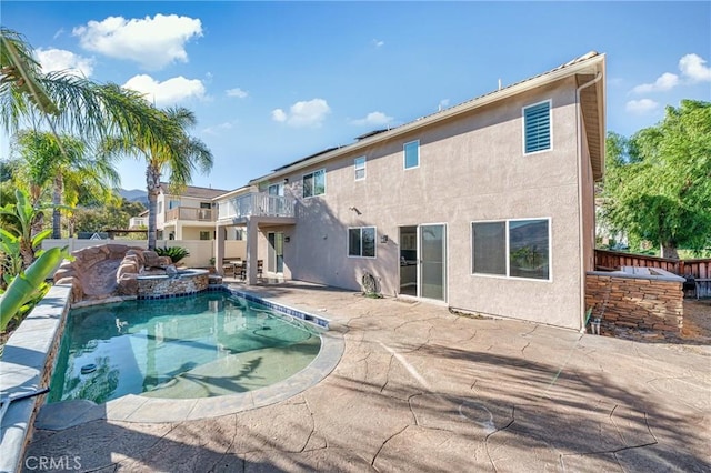 back of house with a patio, a fenced in pool, and a balcony