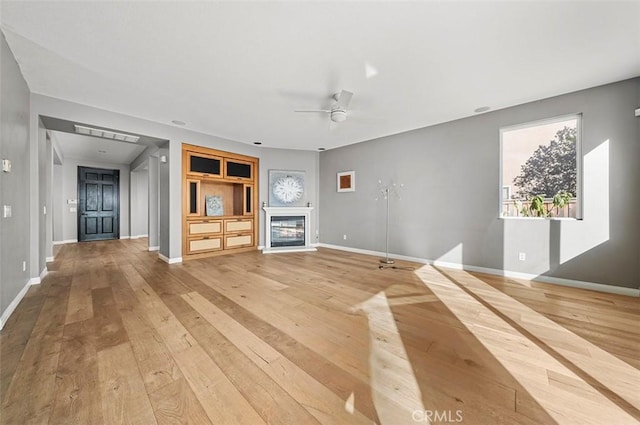 unfurnished living room featuring ceiling fan and wood-type flooring