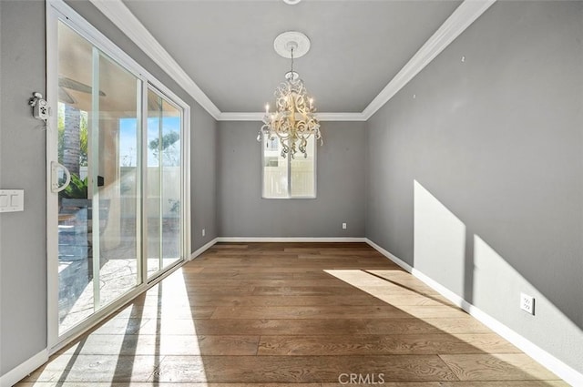 unfurnished dining area with ornamental molding, dark wood-type flooring, and a notable chandelier