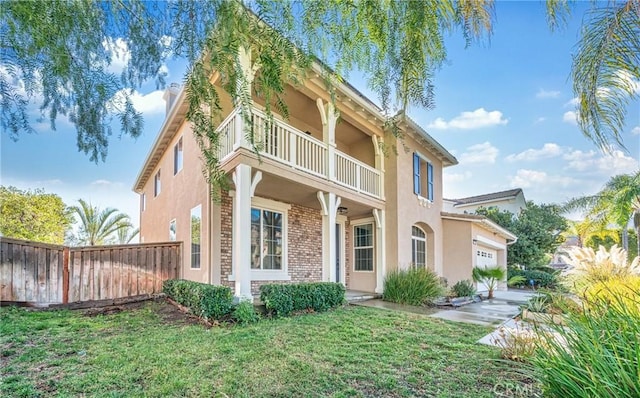 view of front of home with a garage, a balcony, and a front lawn