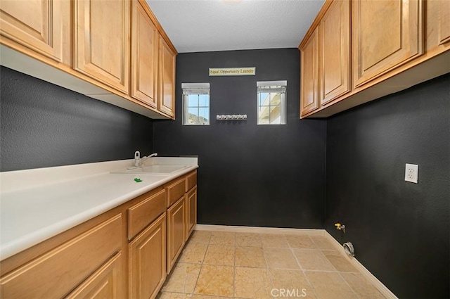 laundry area with cabinets and sink