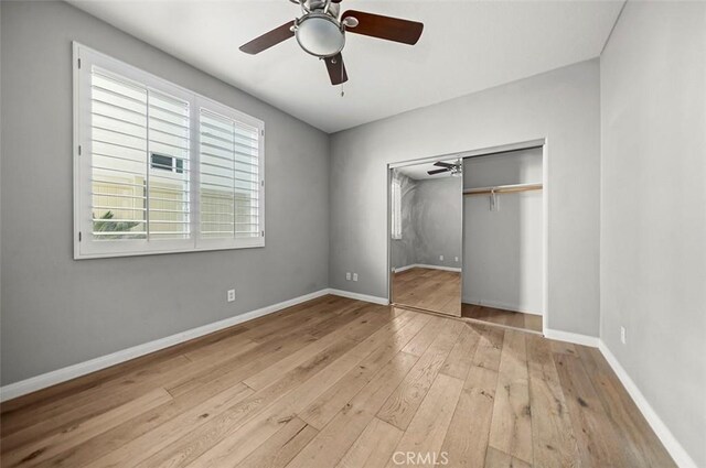 unfurnished bedroom with ceiling fan, light wood-type flooring, and a closet