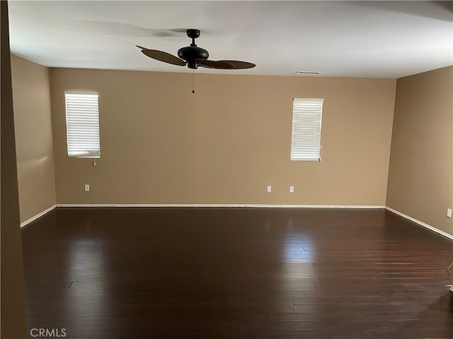 empty room with ceiling fan and dark hardwood / wood-style floors