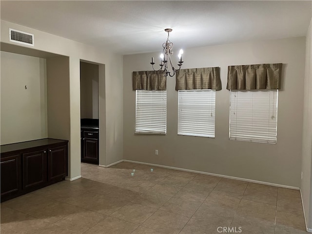 unfurnished dining area with light tile patterned flooring and a chandelier