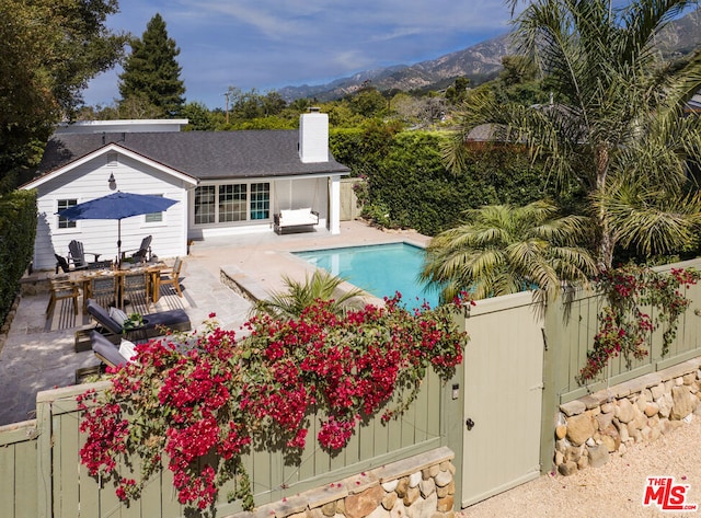 view of swimming pool featuring a patio area and a mountain view