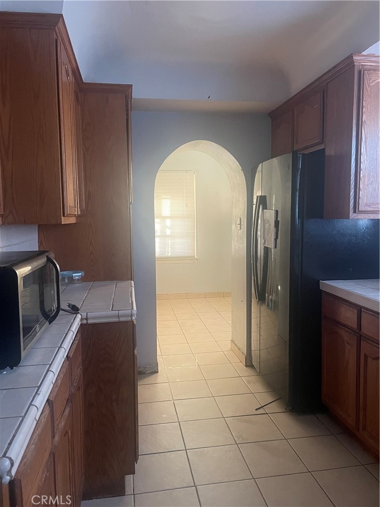 kitchen with light tile patterned floors and tile countertops