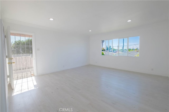 empty room featuring crown molding and light hardwood / wood-style floors