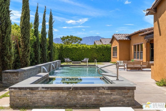 view of swimming pool featuring a mountain view, outdoor lounge area, pool water feature, and a patio