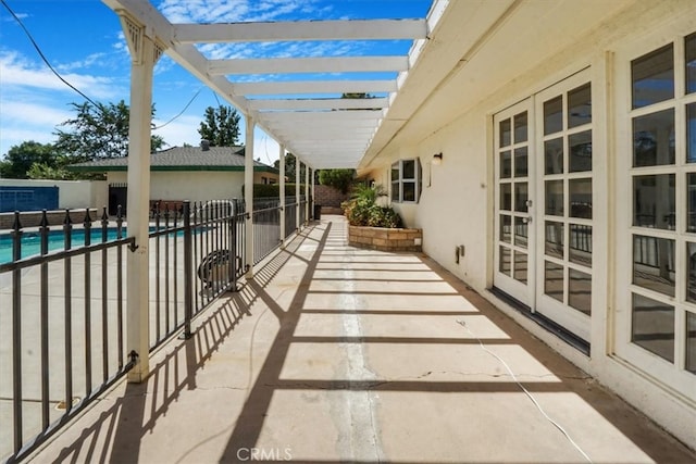 view of patio / terrace with a pergola, french doors, and a community pool