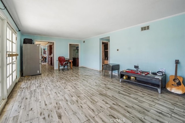 interior space featuring crown molding and light hardwood / wood-style flooring