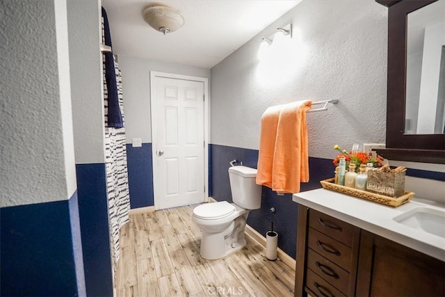 bathroom featuring vanity, toilet, and wood-type flooring