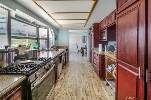 kitchen with sink, appliances with stainless steel finishes, and light wood-type flooring