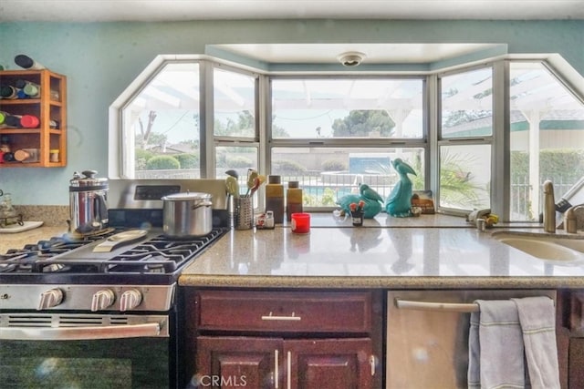 kitchen with stainless steel gas stove, sink, and plenty of natural light