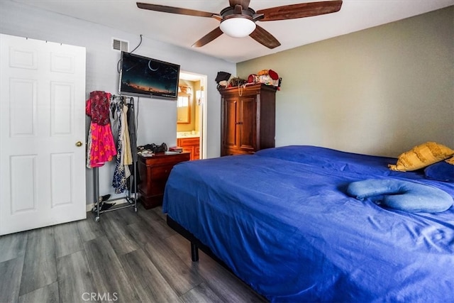 bedroom with ensuite bathroom, dark hardwood / wood-style floors, and ceiling fan