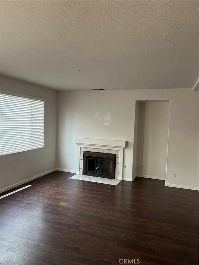 unfurnished living room featuring hardwood / wood-style flooring, a fireplace, and a textured ceiling