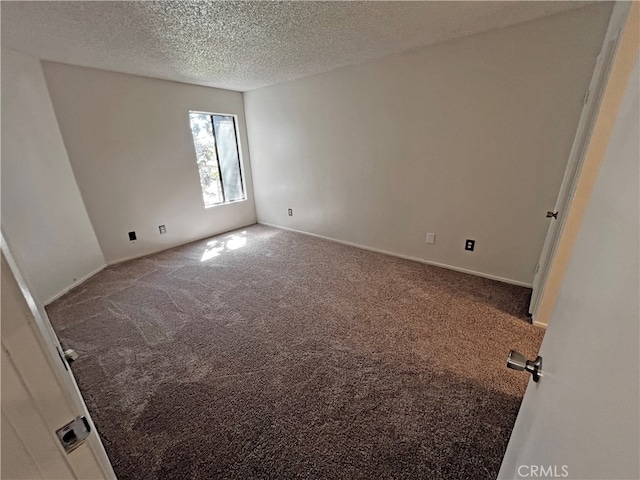 unfurnished room featuring a textured ceiling and carpet