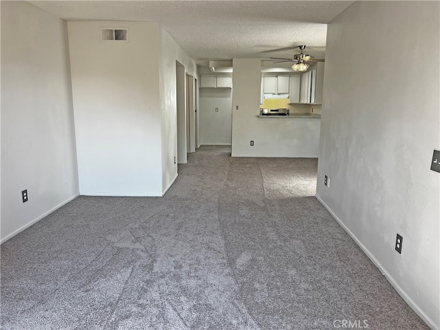 unfurnished living room featuring ceiling fan, a textured ceiling, and carpet flooring