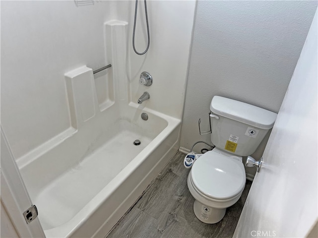 bathroom featuring wood-type flooring, toilet, and shower / bathing tub combination