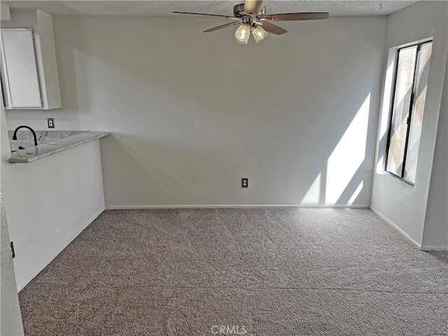 interior space with a textured ceiling and ceiling fan