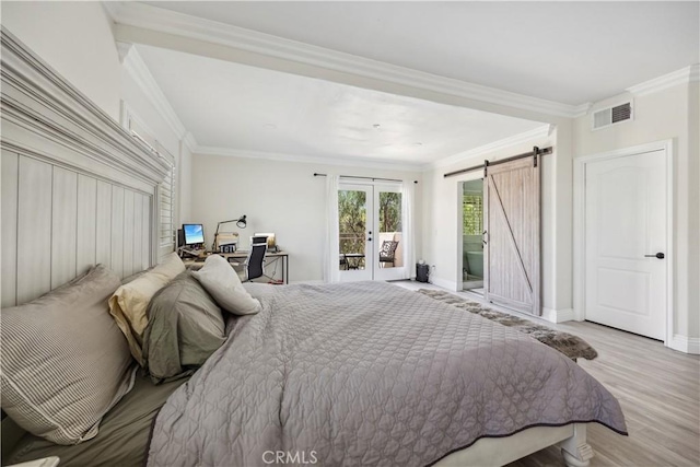 bedroom featuring french doors, access to exterior, light wood-type flooring, ornamental molding, and a barn door