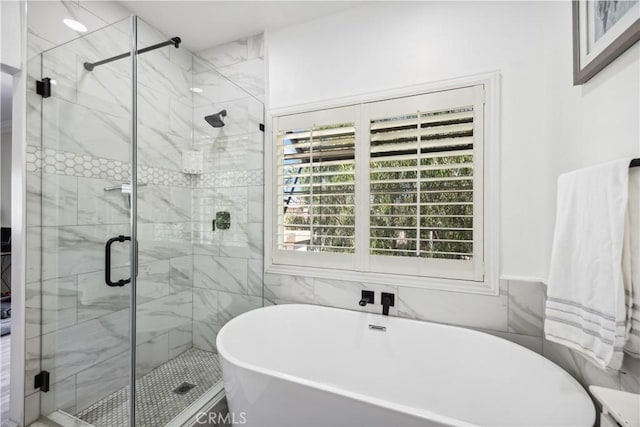 bathroom featuring independent shower and bath