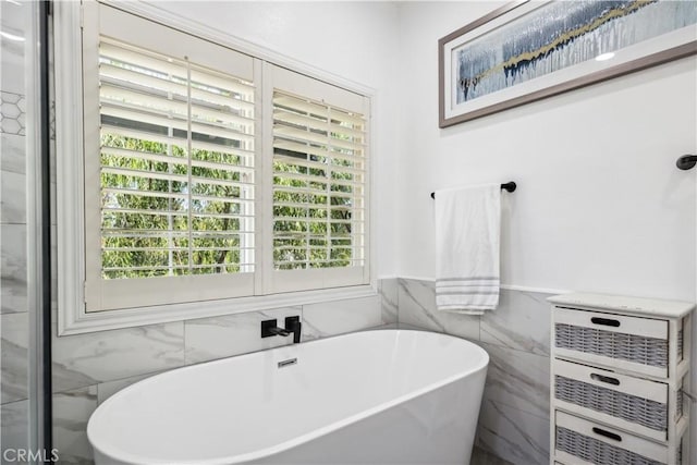 bathroom featuring tile walls and a bathing tub