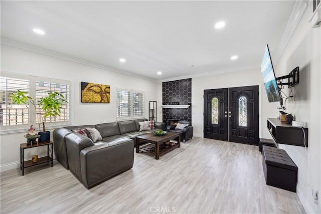 living room with crown molding, a fireplace, and light hardwood / wood-style flooring