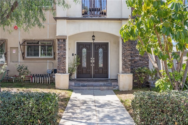 entrance to property featuring a balcony and french doors