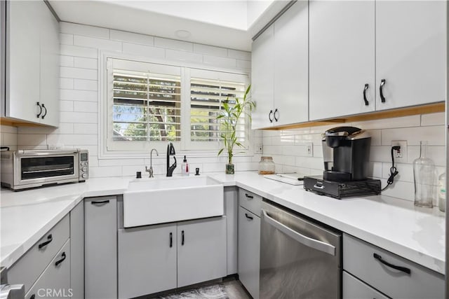 kitchen featuring sink, stainless steel dishwasher, and decorative backsplash