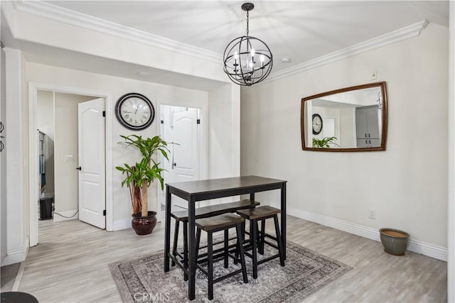 dining area featuring ornamental molding, a chandelier, and light wood-type flooring