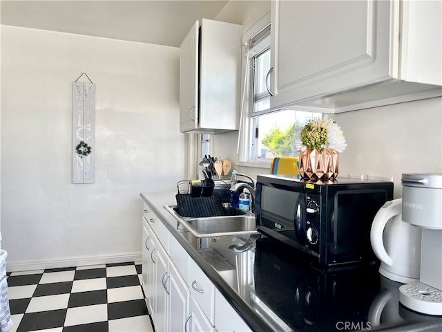 kitchen featuring white cabinets and sink