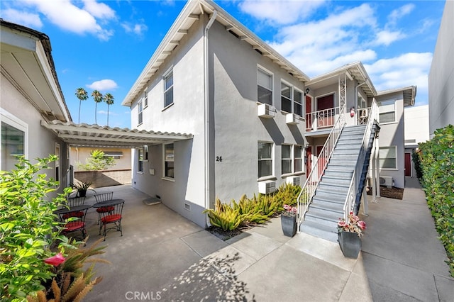 view of property exterior featuring a patio, cooling unit, and an AC wall unit