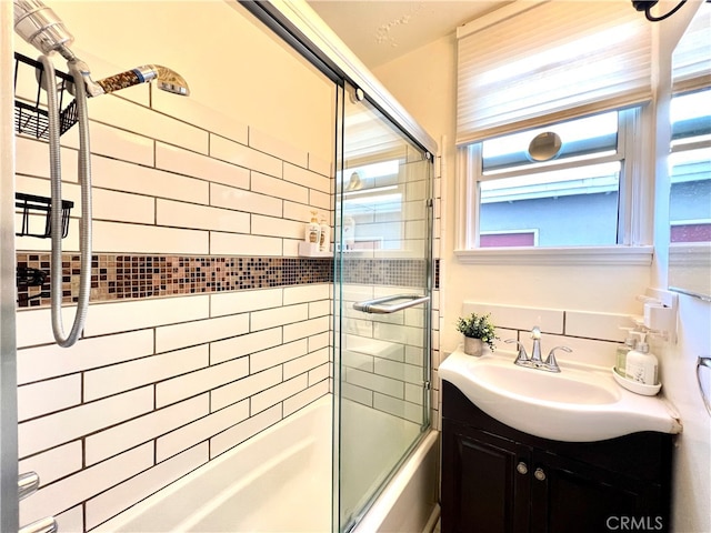 bathroom featuring tile walls, vanity, and combined bath / shower with glass door