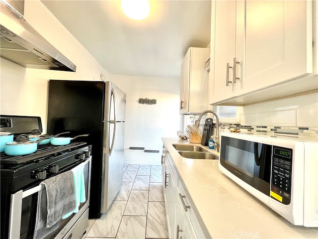 kitchen with sink, stainless steel gas stove, white cabinetry, and range hood