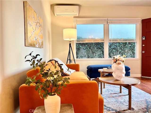 sitting room with a wall unit AC and hardwood / wood-style floors