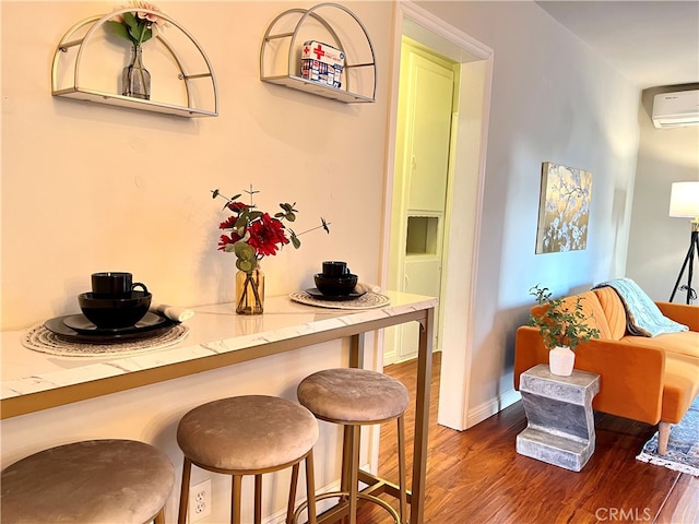 dining area featuring an AC wall unit and dark hardwood / wood-style floors