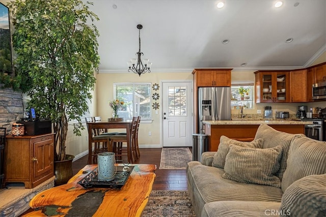 living room featuring ornamental molding, an inviting chandelier, dark wood-type flooring, and sink