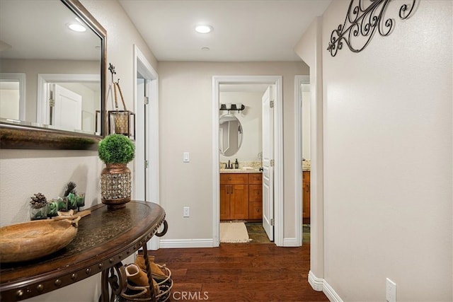 corridor featuring dark wood-type flooring and sink