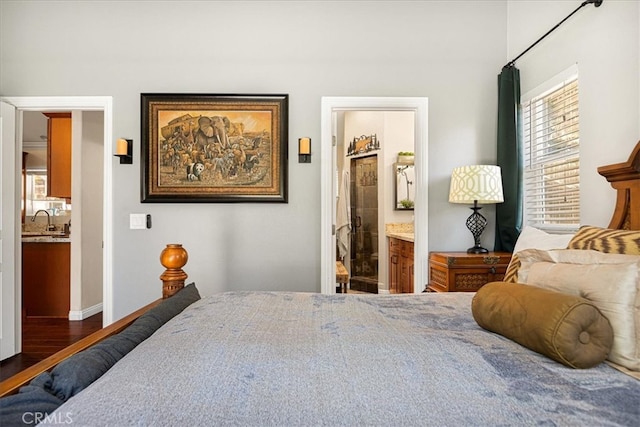 bedroom featuring ensuite bath, dark hardwood / wood-style floors, and sink