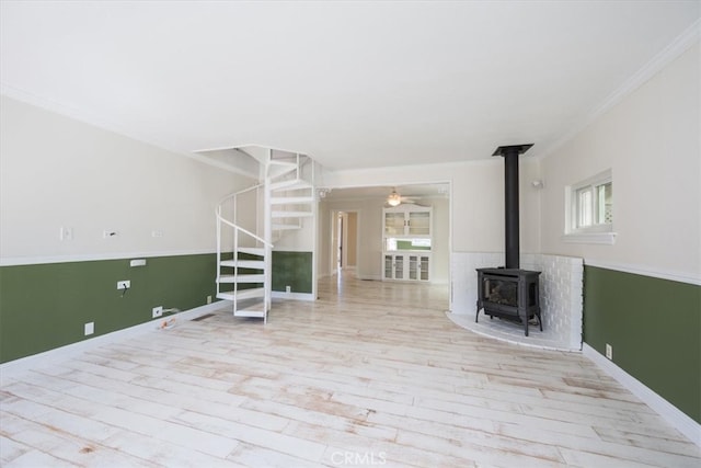 unfurnished living room featuring ceiling fan, light hardwood / wood-style floors, a healthy amount of sunlight, and crown molding