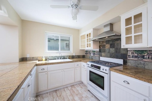 555 Le Point St, Arroyo Grande, CA 93420 - kitchen featuring glass insert cabinets, wall chimney range hood, white gas stove, tile countertops, and a sink
